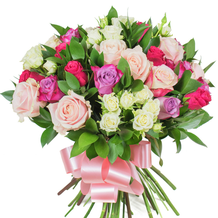 A luxuriant, densely rounded bouquet of mixed roses is presented on a pure white backdrop, each element placed to show craftsmanship and natural beauty. At the centre lie numerous large roses in soft pastel pink and creamy white; some blooms are fully unfurled to reveal layered, velvety petals, while others hold their shape as graceful buds, creating a rhythm of openness and restraint. Interspersed among them are vivid deep fuchsia or magenta roses that introduce vivacious contrast, and a handful of pale lavender roses that cool the palette with gentle, powdery tones. Clusters of smaller spray roses-predominantly creamy white with whispered pale-yellow centers-are tucked into pockets across the arrangement, lending texture and tiny focal points that invite a closer look. Glossy, dark green foliage-likely ruscus or salal-frames and supports the flowers, the elongated leaves adding sculptural lines and a verdant backdrop that intensifies the roses' colours. The long stems are gathered into a neat hand-tied base and finished with a wide baby-pink satin ribbon tied in an elegant bow whose sheen mirrors the soft lustre of the petals. Under soft, neutral lighting the bouquet's hues read true and fresh; you can almost picture the faint, classic scent of roses blended with a dewy green note. Made with local knowledge and care from Brent Cross Flowers, this arrangement conveys romance, gratitude and celebration-suitable for Valentine's Day, Mother's Day, anniversaries or as a thoughtful gift for someone in and around Brent Cross, Hendon and Mill Hill.