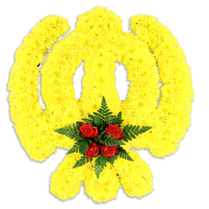 Dominating a stark white field, this large Khanda emblem is meticulously shaped from thousands of small, sun-bright yellow chrysanthemums so closely packed that the surface reads like a soft textile of petals. Every element of the Sikh symbol is faithfully rendered - the circular chakkar, the upward sweep of the central double-edged khanda and the pair of crossed kirpans - their outlines softened by the chrysanthemum's ruffled texture yet precise in form. At the point where the components converge sits a concentrated focal cluster of five to six deep red roses, each rosebud tight and satin-smooth, surrounded by swathes of deep green fern fronds that provide a cool, leafy counterpoint to the warm yellow. The white background and a subtle grey shadow beneath suggest a physical, freestanding tribute suitable for a funeral display, gurdwara ceremony or a civic remembrance; it reads both as a statement of faith and as a carefully composed floral artwork. The overall feeling is one of reverence: the yellow blooms impart gentle consolation and light, while the red roses register quiet love and respect. Close observation reveals the florist's hand in the symmetry and density of the packing, choices made for visual impact from a short distance and tactile softness up close. I imagine this piece being placed with care at a service near Brent Cross's community spaces or transported along Cricklewood's lanes to a local memorial - an offering of colour, scent and heartfelt craftsmanship.