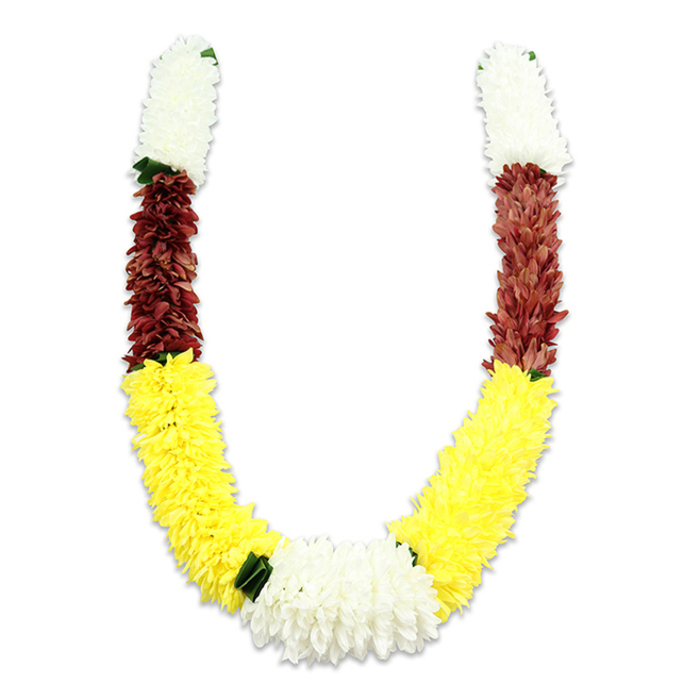 This image shows a U-shaped, traditional mala rendered in artificial blooms, photographed on a pure white background so every hue and texture reads clearly. The garland's structure is deliberate: each arm begins with a dense, cylindrical cluster of creamy-white, chrysanthemum-like fabric flowers that feel airy and refined, signalling purity at the top. A narrow transition into a rich maroon or rust-red band provides a deep, devotional counterbalance, its small, tightly arranged petals giving the segment a compact, tactile density. Below that, a long, plush field of bright yellow blossoms - evoking marigolds in tone if not material - curves gracefully to form the body of the U, the colour carrying a cheerful, auspicious energy. At the central bottom a generous mound of white flowers ties the two arms together, creating a luminous focal point, while tiny dark-green leaf accents are placed at key junctions to separate and accentuate the colour blocks. The synthetic fabric catches a soft studio light, the shadowing revealing the meticulous handwork that arranges thousands of petals into a uniform, full-bodied garland. In practical terms this durable construction makes the mala suitable for repeated use in Hindu pooja, temple decoration, wedding ceremonies, Diwali and Holi displays, or as a dignified offering. As a local florist in Brent Cross, Brent Cross Flowers appreciates how such a piece complements altars at home or community events near Brent Cross Shopping Centre, Cricklewood Broadway or Hendon Park, where colour and tradition are celebrated with care.