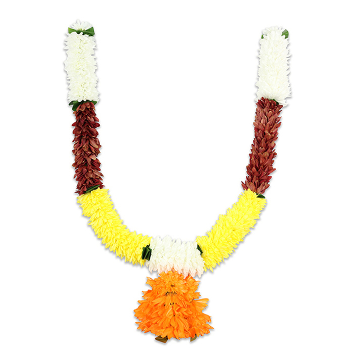 An expertly assembled U-shaped toran, photographed flat against a white background so its layered workmanship is unmistakable. Each arm opens with a short, vertical cluster of creamy-white florets - densely packed, pillow-soft and reminiscent of small chrysanthemums - capped with a subtle dark-green hint where a loop or hanging tie would sit. Below these pale crowns, a compact segment of deep reddish-brown provides a tactile middle tone: the elements appear slightly flattened and leathery, suggesting the look of dried petals or richly stained fabric that anchors the piece. From there the garland broadens into a generous band of sunny yellow - bright, marigold-like pom-poms arranged in a continuous curve that forms the main U, their fluffy texture catching light to create a sense of warmth and movement. At the lowest central point a large, layered pendant of orange ruffled petals hangs like a celebratory tassel, its saturated colour drawing the eye and suggesting auspiciousness and festivity. Small green accents are threaded between colour blocks, offering leafy punctuation and visual rhythm. The artificial materials - fine silk-like petals and robust craft fibres - give the garland a lasting, reusable quality suitable for indoor and sheltered outdoor displays, ideal for homes and community spaces in Brent Cross, Cricklewood or nearby Dollis Hill during Diwali, Ganesh Chaturthi, weddings or other puja ceremonies. As a florist who works locally, I value how such a piece preserves ritual beauty without the immediacy of fresh flowers, maintaining colour, form and reverence across repeated celebrations.