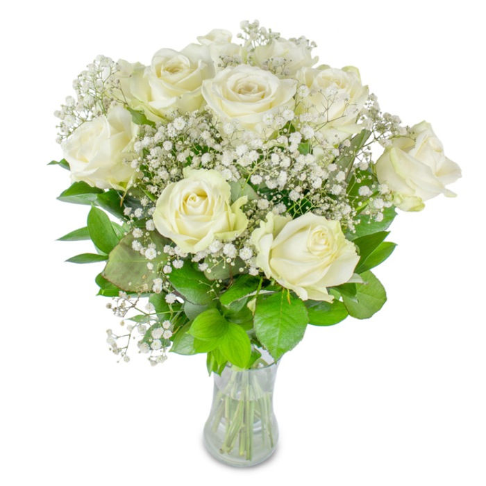 This composition of approximately twelve white roses surrounded by abundant baby's breath reads like a study in refined simplicity, pictured against a pristine white field that emphasizes every tactile detail. Each rose presents a slightly different moment of bloom - from compact buds with tightly furled petals to generous, fully opened cups whose creamy layers have a faint translucence at the edges - offering a sense of movement across the arrangement. The Gypsophila acts as a delicate counterpoint: innumerable tiny white blooms create an airy network, softening the silhouette and lending the bouquet an almost celestial halo. The supporting greenery, varying from rich forest tones to bright lime accents, is placed for both aesthetic depth and botanical balance; leaves cradle the flowers and their glossy textures reflect soft light. The bouquet is set in a clear glass vase, intentionally minimal, allowing the trimmed green stems and the visible water level to announce freshness and careful preparation. The overall mood is one of quiet celebration and thoughtful restraint - suitable for a refined wedding, a meaningful anniversary, or a serene memorial. As a florist who has arranged similar bouquets for receptions near Brent Cross Shopping Centre and ceremonies at nearby parks, I would describe the fragrance as faint and fresh, more evocative than intrusive, inviting a reflective pause. This is a floral gesture that prioritises presence over extravagance, offering a pure, composed beauty that feels both intimate and universally understood.