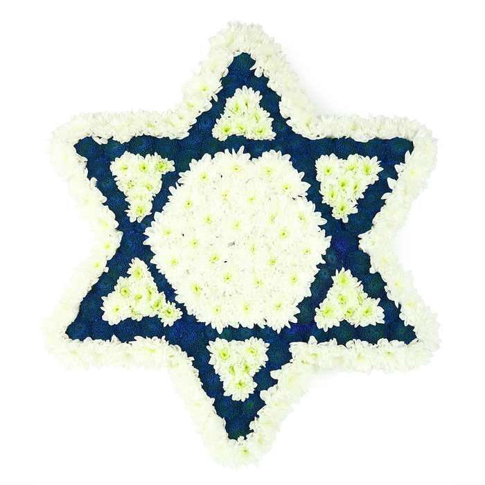 A meticulously crafted Star of David funeral tribute is shown in full view, resting against a clean white background that makes the floral design appear almost sculptural. The six-pointed star is created entirely from fresh flowers, with an emphasis on crisp white and rich, dark blue hues. Along its edge, a generous border of white chrysanthemums and other compact, many-petalled blooms forms a soft, ruffled frame, each blossom touching the next so closely that the perimeter looks like a continuous ring of snow. Inside this border, at the very centre of the star, a broad white hexagon is composed of similar flowers, clustered so tightly that they create a smooth, uniform surface. Surrounding this hexagon, the six arms of the Star of David extend outward in precise triangles, filled with dense clusters of deep navy-blue flowers that bring a sense of depth and quiet solemnity, reminiscent of the evening sky over Brent Cross and the neighbouring Hendon area. At the inner base of each point, a smaller, carefully defined triangle of white blooms punctures the blue, setting up a sophisticated interplay of light and dark that reinforces the familiar lines of the Magen David. The texture of the arrangement is lush and tactile, suggesting the gentle rustle of petals when moved from workshop to service. This piece would be especially fitting at a Jewish funeral, remembrance service, or shiva held in and around Brent Cross, from synagogues on nearby residential streets to homes where family and friends gather to mourn. It conveys both cultural identity and heartfelt condolence, offering a peaceful focal point in moments of shared grief.