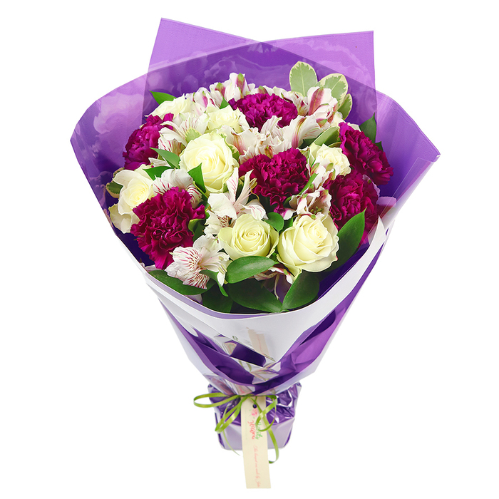 Against a pure white backdrop, this bouquet appears as a vivid composition of creamy whites, rich magentas, and fresh greens, thoughtfully arranged for an uplifting effect. At the centre, cream-white roses hold pride of place, their petals starting in tight spirals and gradually loosening into softer, open curves that give a sense of gentle movement. Encircling them, deep magenta carnations create a ring of ruffled texture, each bloom made up of countless tiny folds that lend depth and visual interest. Threaded throughout are graceful stems of white alstroemeria, the Peruvian lilies distinguished by narrow petals delicately streaked with pinkish-red lines and finished with prominent dark stamens that add a subtle contrast. The greenery is equally important: glossy green leaves and a few variegated sprigs with pale edges peek through the flowers, adding volume, framing the blooms, and suggesting a bouquet freshly prepared for delivery around Brent Cross's shopping and residential areas. The florist has gathered the flowers into a round, full shape at the top, then allowed the stems to taper naturally, forming a balanced silhouette. Around the blooms, an inner collar of crisp white paper hugs the stems, providing a bright, neutral frame that sets off the colours beautifully. Over this, a translucent sheet of purple cellophane or tissue is wrapped in gentle folds, its soft crinkles catching the light and creating a shimmering effect that feels celebratory and modern. The wrapping is finished at the base with a neat bow of bright lime green satin ribbon, whose reflective sheen echoes the freshness of the foliage. Dangling from this bow is a small, light brown rectangular gift tag, blank and ready for a handwritten note to a loved one in Brent Cross, whether for a birthday, anniversary, or simple 'thinking of you' gesture. The overall impression is of a carefully crafted, cheerful bouquet that balances elegance with heartfelt warmth.