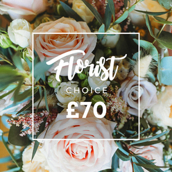 An intimate, elevated view of a curated, artisan bouquet arranged with confident restraint: generous, open-headed roses in pale blush, creamy ivory and soft peach form the visual heart, while a few dusty mauve or lavender-tinged roses add a whisper of contrast. Nestled among these main blooms, tiny white fillers and sprigs of pink-tinted waxflower create a breathy, intricate underlayer, like a soft veil of detail. Textural dried accents in warm cream and tan - feathery grasses and compact seed pods - introduce an organic, slightly wild note that catches light differently from the fresh petals, adding depth and a natural rhythm. The foliage is predominantly rounded eucalyptus leaves in a muted blue-green, their smooth surfaces and cool aroma threading through the bouquet and anchoring the palette. Natural daylight skims across the petals, illuminating veins and subtle colour gradations while the background falls gently out of focus to keep attention on the arrangement's centre. Overlaid on the florals is a simple white rectangular frame with clear typographic hierarchy: the flowing script "Florist Choice," the smaller sans-serif "CHOICE" beneath it, and the prominent price "?70" in bold white numerals. This composition reads as a signature offering from a neighbourhood florist - thoughtful, handcrafted and suited to birthdays, small celebrations or an elegant surprise. Picture this bouquet delivered to a home near Brent Cross Shopping Centre or tucked into a car heading toward Cricklewood or Golders Green, its scent and soft colours promising a quiet, uplifting moment.