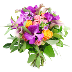 This lavish hand-tied bouquet, photographed against a pure white backdrop, feels like a burst of colour carefully orchestrated by an experienced Brent Cross florist who understands both drama and subtlety. Bold Vanda orchids sit proudly at the centre, their large petals drenched in vivid purple and fuchsia, intricately speckled with paler tones that create a hypnotic, netted effect. Around these exotic blooms, bright orange roses cluster in generous groups, each rose a perfect swirl of petals that radiate warmth, joy, and a touch of playful energy. Interwoven with them are soft, pastel pink roses in various stages of opening, from smooth, rounded buds to partially unfurled blossoms, lending romance and a gentle, almost blush-like softness to the composition. Tall, slender calla lilies in shades of plum, dusty mauve, and muted lavender rise through the bouquet with sculptural grace, their trumpet-shaped blooms providing elegant vertical lines. Delicate filler flowers in lavender and lilac peek out between the larger heads, adding intricate, lace-like detail and transitioning smoothly between the dominant colours. The foliage is abundant and thoughtfully layered: slender, silvery eucalyptus leaves arc outward, catching the light with a cool sheen, while deeper green leaves form a dense underlayer, giving the bouquet structure, depth, and a sense of natural movement. At the base, the stems are gathered and visible, tied in a tight, professional finish that speaks of freshness and hand-crafted quality. This striking design, with its mix of tropical vibrancy and garden softness, would be at home gracing a dining table in a flat near Hendon, welcoming guests in a shop close to Brent Cross Underground station, or marking a significant life moment such as an engagement, milestone birthday, or graduation celebration within the local community.