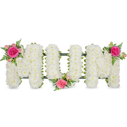The photograph shows a striking funeral flower tribute spelling out the word "MUM" in bold capital letters, aligned neatly on a dark green frame and isolated against a clean white background. Every letter is fashioned from a dense blanket of white spray chrysanthemums, each bloom pressed close to the next so the eye reads a continuous field of petals rather than individual stems. The flowers appear fresh and luminous, their small, rounded heads creating a soft, padded texture that invites the imagination to trace each curve and corner. Beneath the flowers, the slim green framework peeps through at the edges, giving the arrangement structure without stealing attention. To soften the formality of the block lettering, the florist has added three identical accent clusters. On the top left of the first "M", a vibrant fuchsia rose opens in full bloom, embraced by smaller pink spray roses and closed buds that hint at life continuing. Wispy sprigs of green fern arch from the cluster, introducing a gentle movement that contrasts with the solid white foundation. A second cluster sits snugly at the lower centre of the "U", while a third crowns the upper right of the second "M", visually balancing the design from left to right. The combination of pure white chrysanthemums and warm pink roses conveys a message of respect, tenderness, and enduring love. This is the kind of bespoke floral lettering families in Brent Cross might choose for a service at a local crematorium or cemetery, a heartfelt way to say farewell to a much-loved mother and to reflect on shared memories and the warmth she brought into their lives.
