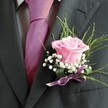 There is a gentle poetry in this boutonniere, a floral artifact that echoes the spirit of connection and celebration flowing through Brent Cross gatherings. Nestled on a smart charcoal lapel, the blush-pink rose at the heart of the arrangement unfurls with quiet vibrancy, carrying a fragrance and softness suggestive of the promise that special mornings hold near Brent Cross Shopping Centre. Layered around the bloom, baby's breath drifts like shimmering mist, accentuating the rose's beauty with ethereal, cloudlike texture. Subtle sweeps of green foliage and leaves lend natural flow, grounding the design and adding a fresh, woodland-like simplicity. A slender ribbon of violet-lilac satin glimmers at the base, uniting every detail with effortless grace and letting the boutonniere shine under soft day lighting. Complemented by the crisp lines of a hot pink tie and an understated patterned shirt, the finished ensemble glows with both tradition and contemporary flair. Each element has been thoughtfully arranged by Brent Cross Flowers' dedicated local florists, ensuring this piece not only illuminates the wearer but also carries the heartfelt joy, anticipation, and sense of place that make Brent Cross occasions truly memorable.