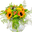Like a ray of sunlight streaming into a Brent Cross living room, this cheerful bouquet brings together the season's brightest blooms in spectacular fashion. The twin sunflowers in front are impossible to miss, their golden petals and bold, dark faces radiating optimism and warmth. Sparking between them, clusters of small yellow flowers and tender coral-orange accents give the entire display an inviting interplay of colours that echoes the glow of late-summer evenings over Brent Reservoir. Fern fronds reach outward, airy and light, while cool eucalyptus and lively lime-green foliage frame the composition in fresh, contemporary style. The clear glass vase adds an extra touch of brilliance, with the flower stems and water combining to reveal the freshness and care behind each arrangement. Crafted by skilled Brent Cross florists who understand the moods of NW4's homes, parks, and bustling avenues, this bouquet is a wonderful way to celebrate friendship, promote healing, or simply invigorate any space with a burst of colour and seasonal charm.