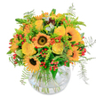 This bouquet blazes with the golden exuberance of summer afternoons spent in Brent Cross, drawing its lively palette from the sunlight filtering through nearby gardens and leafy avenues. Central sunflowers, bold and vibrant, offer a cheerful welcome-each large bloom featuring a dark, velvet core surrounded by radiant yellow petals that seem to glow. Woven between them, yellow roses swirl open with soft, creamy detail, suggesting joy and affection well-suited for birthdays or a heartfelt thank-you. Accents of orange blossoms and shiny crimson berries give the arrangement extra warmth and playful sparks of colour, while delicate ferns-wispy and green-peek out with movement reminiscent of breezes in Hendon Park. Arranged in a rounded, clear glass vase, the bouquet's stems form a natural, artful tangle whose transparency lets the eye follow every element down to the base. The scent is fresh and clean, with subtle foliage notes evoking local gardens. Ideal for uplifting a space or marking special moments, this arrangement from Brent Cross captures the sunny optimism of its neighbourhood, ready to be delivered with care and skill.