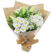 A hand-tied bouquet of cool white blooms stands upright against a clean white backdrop, its composition crisp and quietly joyful. At first glance the eye settles on abundant white, daisy-like chrysanthemums - each bloom layered with many narrow petals that radiate from a warm, sunny yellow centre - creating a cheerful, classic rhythm across the face of the arrangement. Threaded through the chrysanthemums are slender, pale green-yellow lily buds, some faintly striped, their tapered forms hinting at unfolding petals and a gentle, graceful anticipation. Fine clusters of baby's breath (Gypsophila) float like soft white mist between the larger flowers, their tiny blossoms adding an airy, cloud-like softness and delicate texture. Deep green foliage and glossy long leaves cradle the stems, offering a rich contrast that makes the whites read as luminous and pure. The bouquet is wrapped with layered craftsmanship: an inner sheet of crinkled brown kraft paper lends an earthy, tactile warmth, while a clear glossy cellophane outer wrap protects the stems and gives a polished sheen. The base is gathered and tied into a neat, portable stand, the folds of paper and ribbon forming a protective, hand-finished collar. In soft morning light the arrangement suggests the scent of clean linen and a faint green note, like grass after rain, conveying calm, comfort and sincere feeling. This subtly elegant cluster of white lilies, chrysanthemums and gypsophila is versatile - fitting birthdays, new beginnings, heartfelt thank-yous or quiet sympathy - and reads as the kind of thoughtful bouquet you might pick up from a trusted Brent Cross florist for a neighbour or friend.