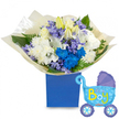 A soft, celebratory bouquet arranged for the arrival of a baby boy, photographed on a clean white background that highlights every texture and hue. At the center sits a lush, rounded cluster of flowers: cream-white roses with gently curled petals, elegant white lilies-some fully open revealing pale yellow stamens while others remain tight buds-and voluminous white chrysanthemums that read like small clouds. Threaded through this serene base are electric blue chrysanthemums and a striking cluster of vivid cobalt blooms that catch the eye and reinforce the traditional blue theme. Sprays of small, periwinkle-lavender florets, likely hyacinth or a similar bell-shaped bloom, weave through the composition, adding delicate scent and soft, cool contrast. The foliage is generous-broad glossy leaves and feathery fern fronds that cradle the heads and give the bouquet a fresh, garden-picked feel. The stems are gathered and wrapped in crinkled, translucent cream paper that softens the transition to the presentation container: a matte royal-blue rectangular gift box that anchors the arrangement with a modern, comforting weight. To the right, a light-blue foil balloon shaped like an old-fashioned baby carriage floats slightly, its canopy and wheels accented in darker blue and dotted with tiny hearts; the phrase It's a Boy is cheerfully printed across the carriage in yellow and lime-green lettering. The overall impression is one of tender celebration-textural, fragrant, and composed with care-perfect for a baby shower, a hospital visit or to welcome a newborn home in Brent Cross, Cricklewood or nearby Childs Hill.