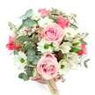 The photograph focuses on a romantic hatbox flower arrangement, set against a pure white background and viewed from a gentle overhead angle that reveals the rounded shape of the bouquet. The hatbox itself is a soft blush pink, its surface smooth and modern, with a slender ribbon in a darker rose-pink encircling it and a small cream tag dangling at the front, as if labelled for delivery somewhere in Brent Cross. Rising from the box is a full, dome-shaped cluster of blooms in soothing shades of pink, white, and green. Light pink roses are the most prominent, some fully open so their velvety, spiralling petals create generous, cup-like shapes, others still just partly unfurled, lending a tender, unfolding quality. Tucked between them are white daisy-style chrysanthemums, whose neatly layered petals ring bright green centres, introducing a crisp, cheerful accent. Among these, white alstroemeria blooms appear, their narrow petals patterned with fine purplish-red streaks and speckles, adding a delicate, almost painterly detail. The arrangement is cradled and enriched by an assortment of foliage: round eucalyptus leaves in a silvery-green tone arc through the flowers, offering cool contrast and gentle texture, while deeper green, strappy leaves, probably from the lilies, create depth and a slightly wilder edge. Small clusters of reddish-brown buds or berry-like forms nestle throughout, enhancing the bouquet's natural, garden-inspired feel. The palette of blush, ivory, and green suggests quiet celebration and warmth, perfectly suited for delivery around Brent Cross for birthdays, anniversaries, or simple just-because surprises, whether it ends up on a coffee table in a home near the shopping centre or brightening an office by the North Circular.