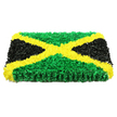 A bold, rectangular floral artwork recreating the Jamaican flag dominates this image, blending cultural symbolism with the tenderness of a funeral tribute often chosen by families in Brent Cross. The panel is built up with visible thickness and rests against a pure white background, which makes the colours appear exceptionally vivid. Running diagonally from corner to corner is a bright golden yellow saltire, forming the unmistakable X-shape of the flag. Each stroke of the yellow cross is composed of countless tiny, ruffled fragments that resemble miniature blossoms, nestled closely together so the surface looks soft, almost cushion-like, yet precisely defined. Above and below, the triangular spaces are filled with a rich, garden-green texture, recalling the look of compact foliage or densely packed chrysanthemums fresh from a North London flower stand. The green conveys a feeling of vitality and renewal, a comforting presence in a time of loss. On the left and right, the black triangles are created from the same closely clustered materials, their deep matte tone adding solemn contrast that grounds the brighter colours. Under even, bright lighting, the entire tribute reveals subtle undulations, shadows, and highlights that make it appear almost sculpted rather than flat. You can imagine running your hand across the surface and feeling the shifting textures as you pass from green to gold to black. Perfect for memorials, church services, or home gatherings around Brent Cross, this detailed Jamaican flag tribute honours both cultural identity and personal memory, standing as a powerful, handcrafted symbol of respect, love, and enduring connection.