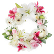 A generous circular wreath of funeral flowers is arranged against a plain white background, allowing every detail of its white, pink, and deep magenta blooms to stand out clearly, as if ready to be delivered to a service in Brent Cross. Large white lilies anchor the design, their broad, silky petals fully open and curving gracefully, each bloom holding a central cluster of fresh green pistils and softly golden stamens. Interspersed among them are vivid fuchsia and magenta lilies, their star-shaped faces and subtle speckling adding richness and contrast, bringing a contemporary vibrancy to the traditional form. Soft light pink roses and creamy white roses are nestled closely throughout the ring, some still in bud and others fully unfurled, their layered, velvety petals conveying love, remembrance, and gentle sympathy. White gerbera daisies, with their distinctive dark centres, appear at intervals, their tidy, radiating petals lending brightness and a touch of modern style, similar to floral displays seen in North West London homes. Smaller white filler blooms-likely spray carnations or fine chrysanthemums-fill every available space, giving the wreath a plush, cushioned appearance and ensuring no gaps interrupt the circle. A generous collar of deep green foliage surrounds the outer edge and lines the inner rim, shaping the wreath into a defined, unbroken ring that symbolises the eternity of love and the continuing bond with the one who has passed. The overall impression is of a carefully crafted sympathy wreath, calm and respectful yet quietly uplifting, ideal for funerals, cremations, or memorial services throughout the Brent Cross area, where flowers are chosen to speak with grace when words are not enough.