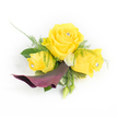 A wearable flourish of summer warmth: three golden yellow roses arranged like a small sunburst against a clean white background, the central bloom fully open and slightly larger, flanked by two smaller, gently unfurling roses. Each rose's buttery, velvety petals cradle a tiny clear faceted jewel at its centre, catching light and adding a discreet, celebratory sparkle. Below the trio a single, sculptural calla lily in a deep plum-burgundy shade curls gracefully down and to the left, its satin-like surface creating a dramatic, grounding contrast to the luminous roses. The composition is softened by feathery asparagus fern fronds that weave airily through the blooms, paired with broader, dark green leaves that give the piece weight and structure. Small, button-like white chrysanthemums nestle among the roses as delicate filler, their creamy centres bringing cool highlights, while a couple of unopened green buds peek from the bottom right, suggesting natural growth and freshness. Behind the left-most yellow rose a whisper of sheer white lace-like material adds an ethereal, slightly vintage accent, catching the light like a soft veil. The scent would be a gentle rose perfume threaded with green foliage notes, the overall feel confident and joyful-ideal for a wedding corsage, prom, or graduation. As a Brent Cross neighbourhood florist might advise, this colour-contrasting accessory reads beautifully in daylight or under evening event lighting, offering an elegant, tactile statement for anyone who wants floral jewellery with subtle glamour.