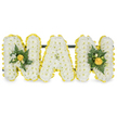 A three-dimensional, hand-crafted sympathy tribute spells out the letters NAN in bold capital shapes, each letter formed from a dense, cloud-like mass of small white chrysanthemum spray blooms. The petals read as soft, almost downy texture under a gentle studio light, with the tiny florets packed closely to create a plush, continuous surface. Each letter is crisply edged by a cheerful line of bright yellow button-style flowers - miniature chrysanthemums or small carnations - that trace the contours and give the design a sunny, uplifting definition against the white. The two outer N letters are enriched with modest clusters of deep green glossy foliage tucked into their uprights: smooth, broad leaves and slender fern fronds that add depth, shadow and a cool, verdant contrast to the warm yellow accents. The central A is deliberately left pristine, allowing the purity of the white base and the yellow outline to speak quietly of dignity and memory. A discreet dark green or black support bar runs behind the top of the letters, unseen from the front but suggested by the steady, upright posture of the display-built for freestanding placement at a funeral, graveside or memorial chapel. The composition gives off a faint, fresh scent of chrysanthemums and cut greenery, and in soft natural light it reads as calm and hopeful. As a local florist serving Brent Cross, I imagine this tribute set against the solemn backdrop of a chapel near Brent Cross Shopping Centre or placed by family at a graveside in nearby Hendon Park; it carries a message of loving remembrance, comfort and gentle celebration of a much-loved Nan.