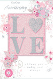 This softly romantic anniversary card captures the feeling of a treasured moment shared between two people, much like receiving a surprise bouquet at your Brent Cross doorstep. The design is woven from delicate pastel pinks, silvery greys, and creamy whites, creating an atmosphere of intimate calm. At its heart, the word LOVE stands out in raised, glittered letters. The glitter is fine and evenly applied, giving a silvery sheen that glows rather than dazzles, inviting touch as much as sight. In some iterations of this style, the letter O is replaced with a shimmering silver heart, textured to resemble a polished charm tucked into a bouquet. Around this central word, soft blossoms in blush and mauve unfurl with a watercolour softness, edges gently blurred as though seen through a romantic haze. The petals are supported by fine, flowing stems and curls, with tiny swirls, petals, and barely there butterflies scattered among them. These details lend a sense of motion, like petals caught in a light breeze along the paths near Brent Cross and the surrounding parks. The inscriptions On Our Anniversary and I love you today and always are written in a graceful, understated script, leaving space for the design to breathe while still expressing deep feeling. The composition as a whole feels tender and reflective-a quiet celebration of shared history and future promises. Paired with a fresh arrangement from Brent Cross Flowers, this card would complete an anniversary gesture that is soft-spoken, elegant, and profoundly heartfelt.